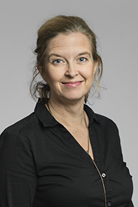 Porträttbild av Pia Skott med neutral bakgrund.